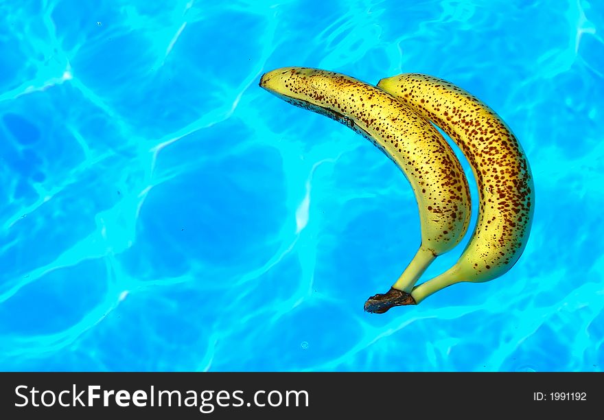 Two ripe bananas floating in a pool. Two ripe bananas floating in a pool