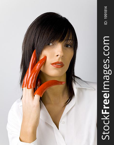 Woman With Red Peppers On Her Fingers. White background in studio. Woman With Red Peppers On Her Fingers. White background in studio.
