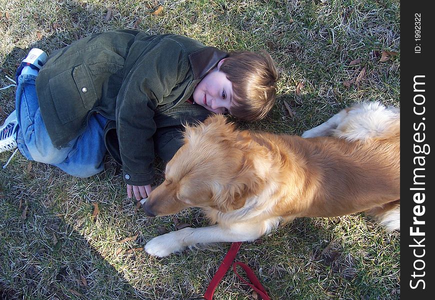 View from above on young boy and golden retriever in field in winter. View from above on young boy and golden retriever in field in winter