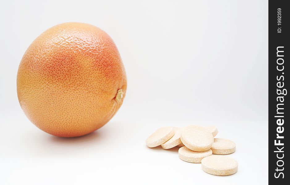 Red grapefruit face pills, on white surface