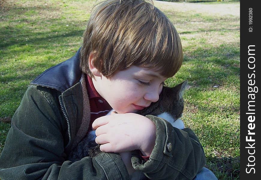 Boy And Cat In Green Grassy Field