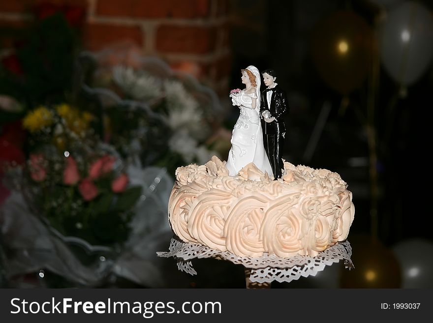 Figures of the groom and the bride at top of a wedding pie. Figures of the groom and the bride at top of a wedding pie