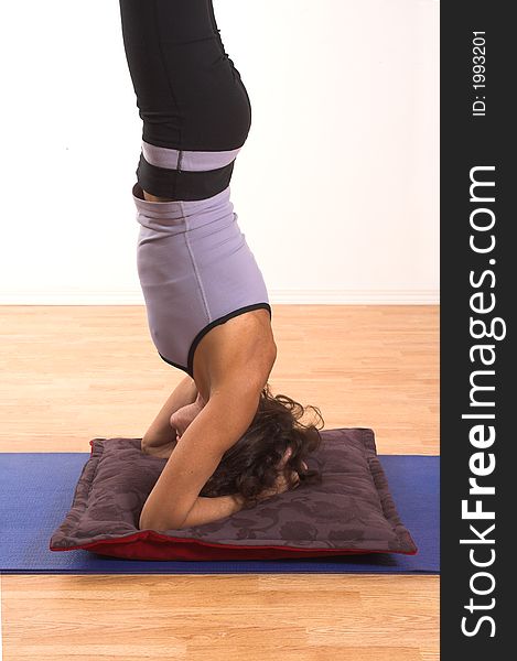 Woman doing yoga on blue mat in studio