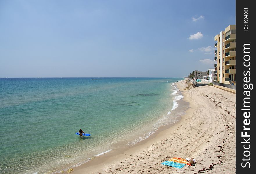 Woman with an air bed on a lonely beach