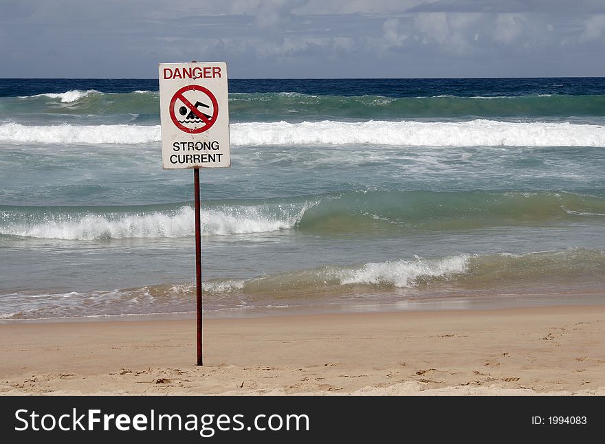 Danger Sign In Front Of Breaking Pacific Ocean Waves At A Sydney Beach, Australia