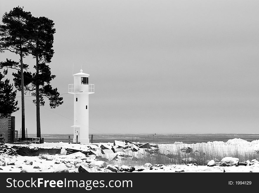Lighthouse on the snowy coastline - black and white