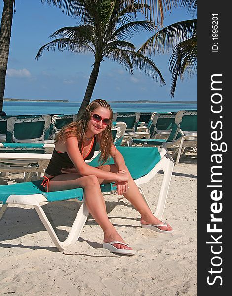 Girl sitting on a couch on a tropical beach. Girl sitting on a couch on a tropical beach