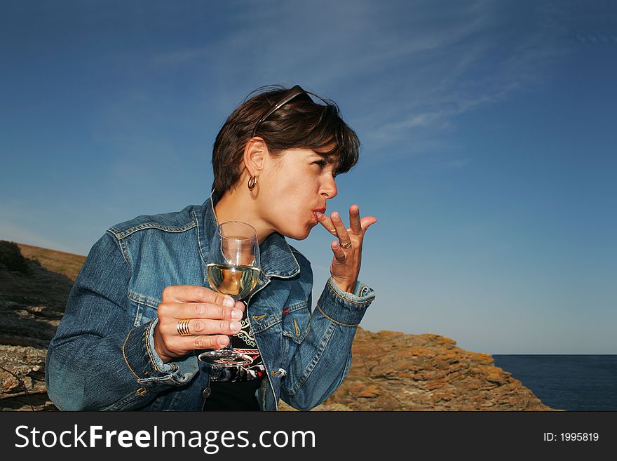 Woman licking her fingers near the sea. Woman licking her fingers near the sea