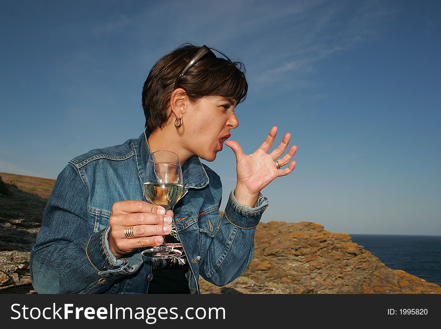 La main, woman licking her fingers near the sea