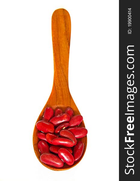 Red beans over wooden spoon isolated on white