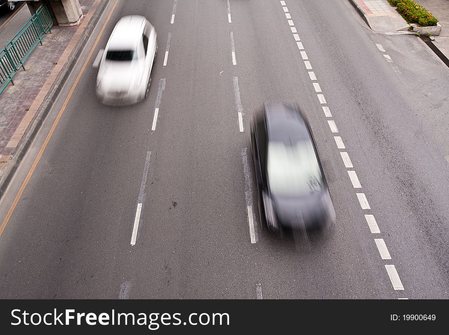 Black and white cars running on the road in motion blur