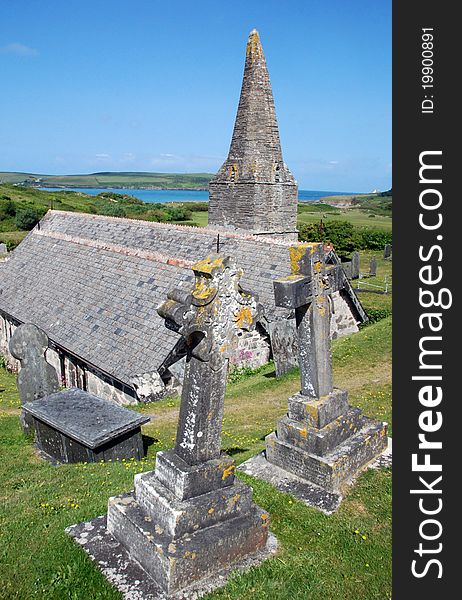 View of St Enodoc Church in Trebetherick, North Cornwall, with the River Camel and the Atlantic Ocean in the background. View of St Enodoc Church in Trebetherick, North Cornwall, with the River Camel and the Atlantic Ocean in the background