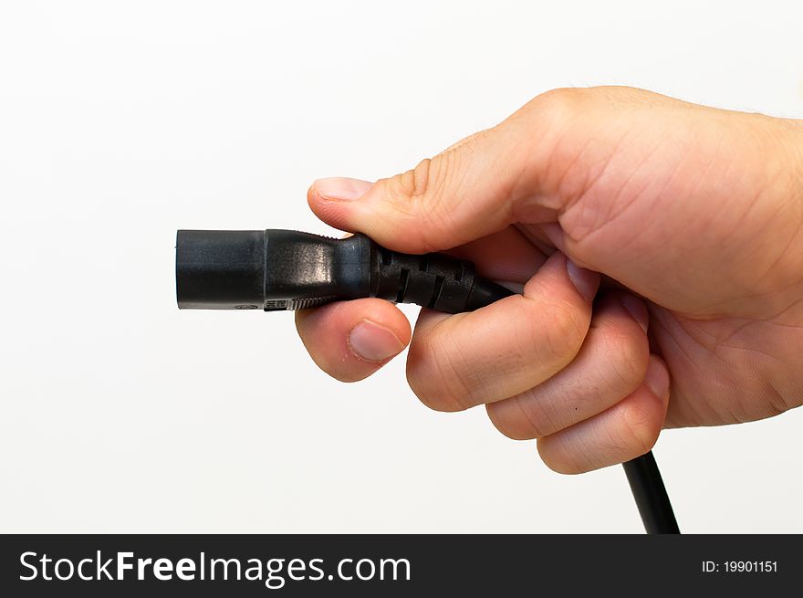 Power supply electrical cord held in a man&#x27;s hand. Power supply electrical cord held in a man&#x27;s hand