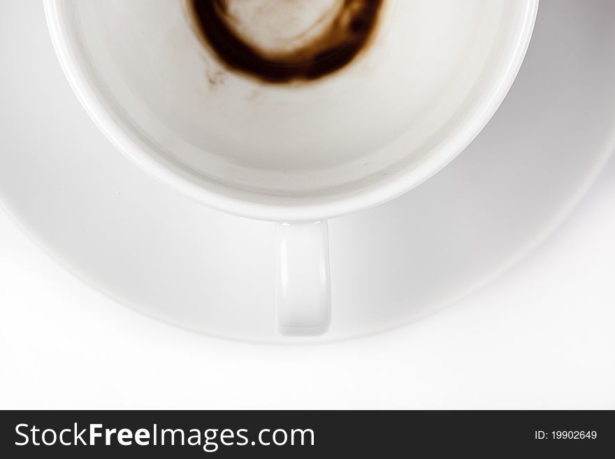 An empty white coffee cup with a stain