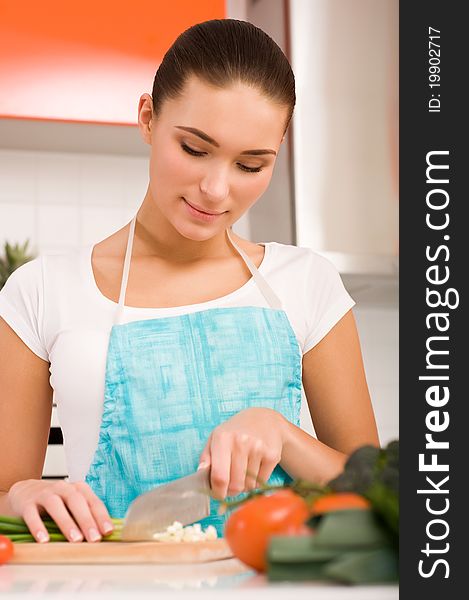 Young woman cutting vegetables in a kitchen