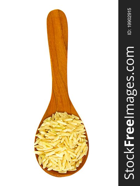 Brown rice over the wooden spoon isolated