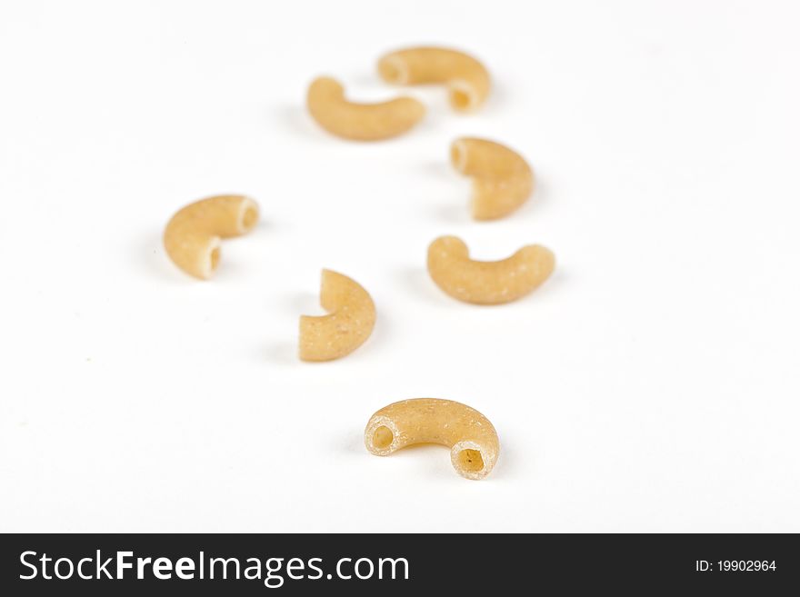 Dry macaroni pasta on a white back ground