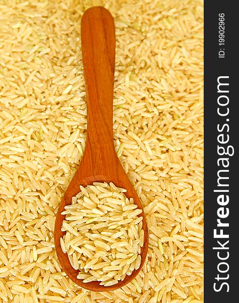 Brown rice over the wooden spoon