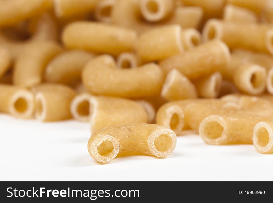 Dry macaroni pasta on a white back ground