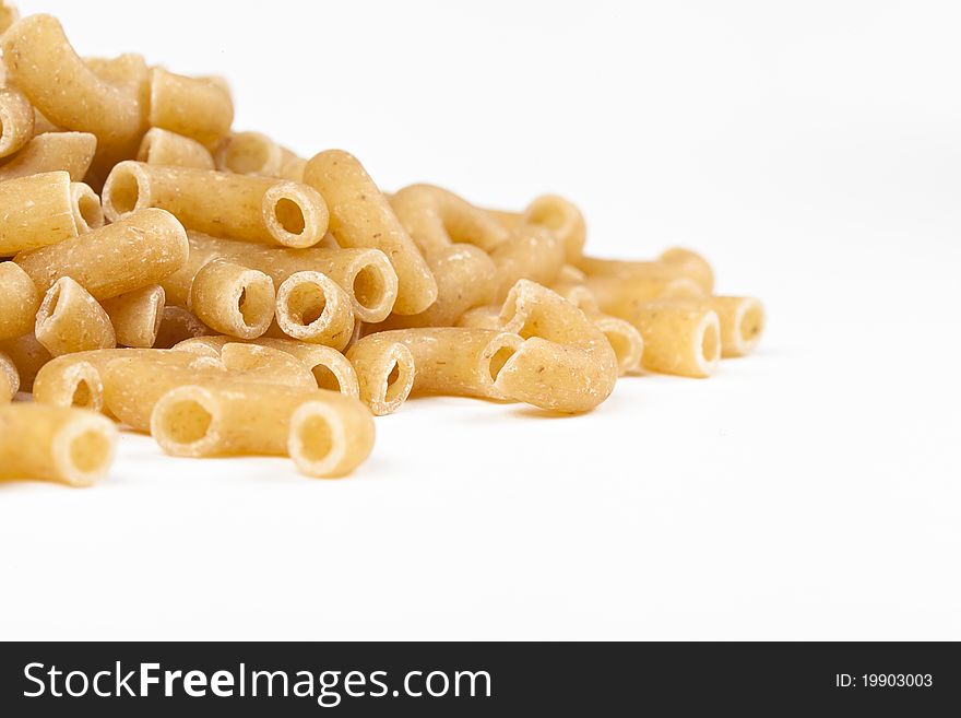 Dry macaroni pasta on a white back ground