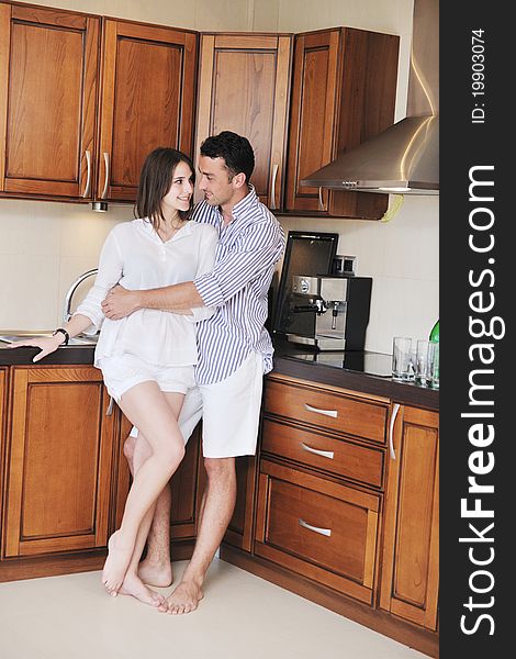 Happy young couple have fun in modern wooden kitchen indoor while preparing fresh food. Happy young couple have fun in modern wooden kitchen indoor while preparing fresh food
