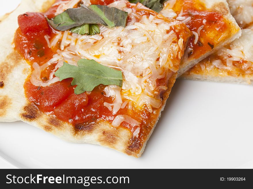 Slices of homemade margarita pizza on a white plate