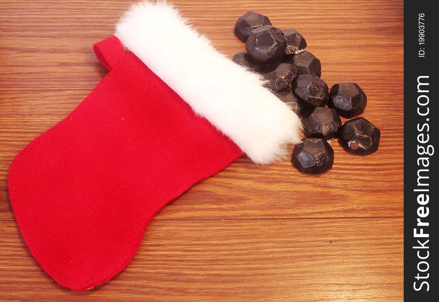 Small child's Christmas stocking with coal spilling out. Small child's Christmas stocking with coal spilling out