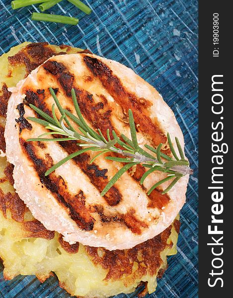 Grilled salmon and roesti with chives and rosemary over a glass dish