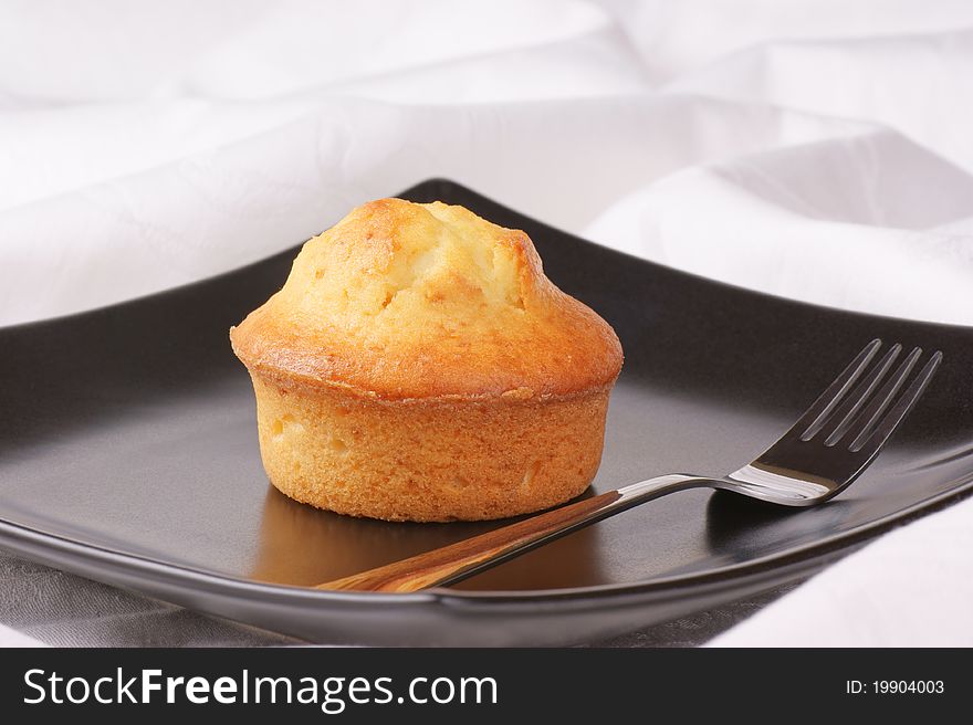 Homemade muffin served on a black plate.