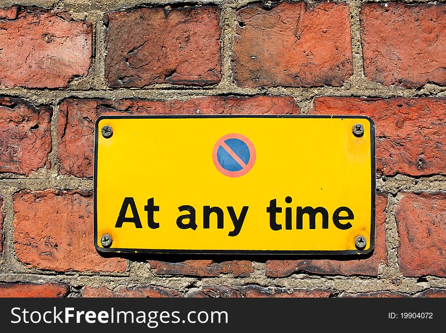 No parking at any time sign on brick wall