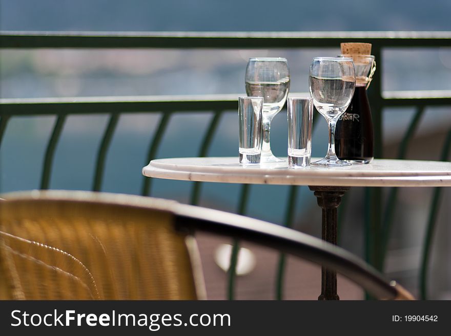 Still life table with glasses and wine on sea coast background