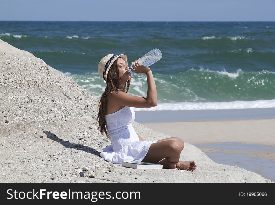 Woman drinking water in the beach