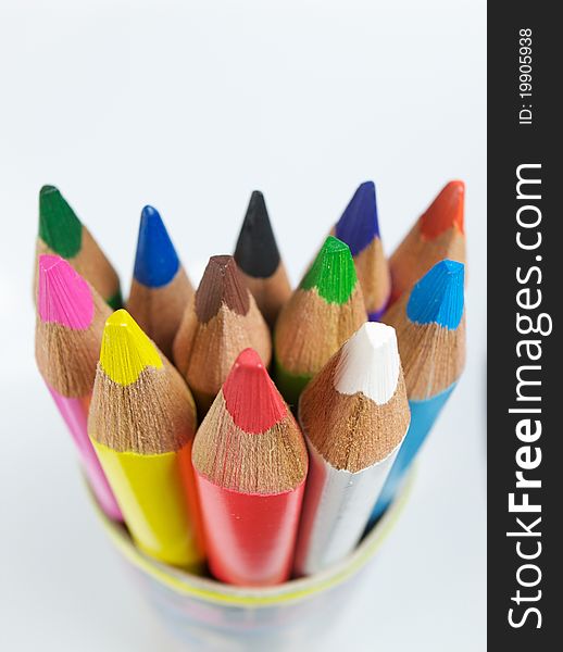 Twelve coloured pencils stood in a pot on a white background. Twelve coloured pencils stood in a pot on a white background