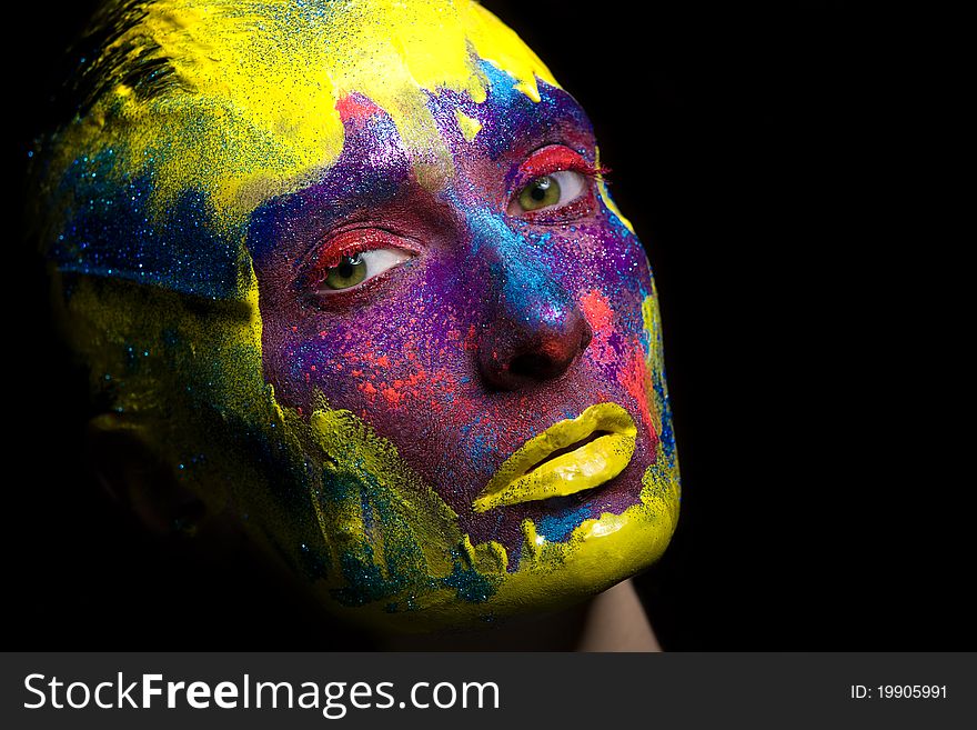 Portrait of an artistic woman painted with colors, over black background. Portrait of an artistic woman painted with colors, over black background.