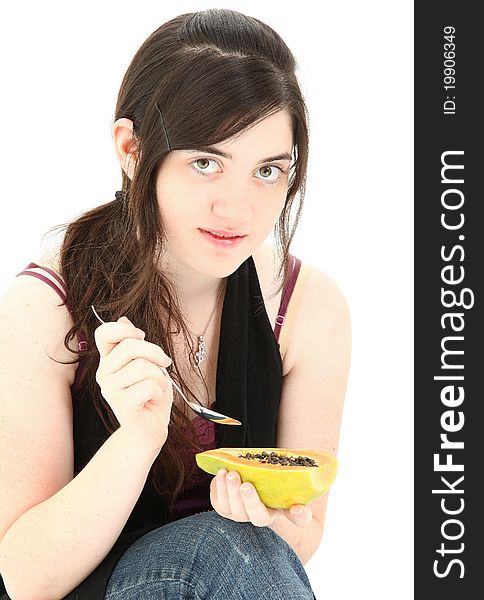 Attractive young woman eating a papaya fruit over white background. Attractive young woman eating a papaya fruit over white background.