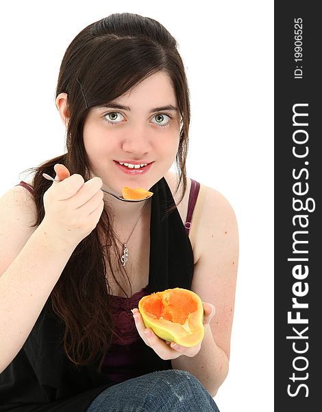 Attractive young woman eating a papaya fruit over white background. Attractive young woman eating a papaya fruit over white background.