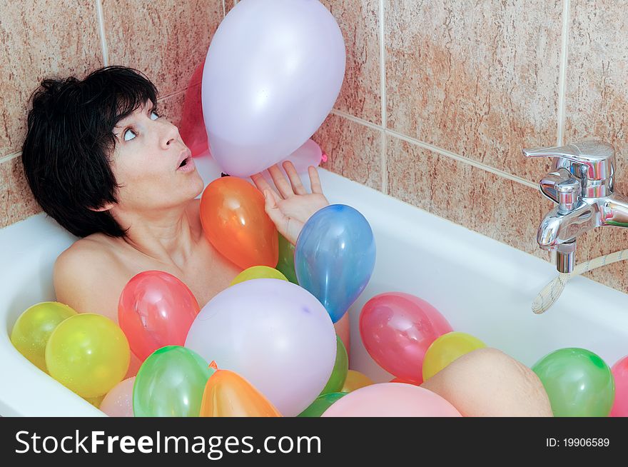 Woman playing with balloons in his bathtub. Woman playing with balloons in his bathtub