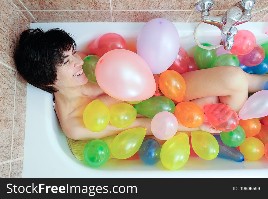 Woman playing with balloons in his bathtub. Woman playing with balloons in his bathtub