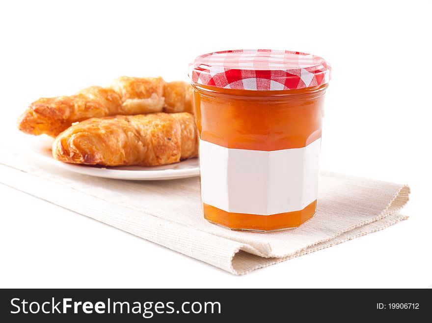 Marmalade and croissants isolated on white