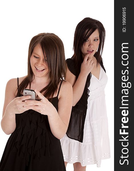 A teen girl looking over a shoulder while her friend is texting and enjoying what her friend is texting. A teen girl looking over a shoulder while her friend is texting and enjoying what her friend is texting.