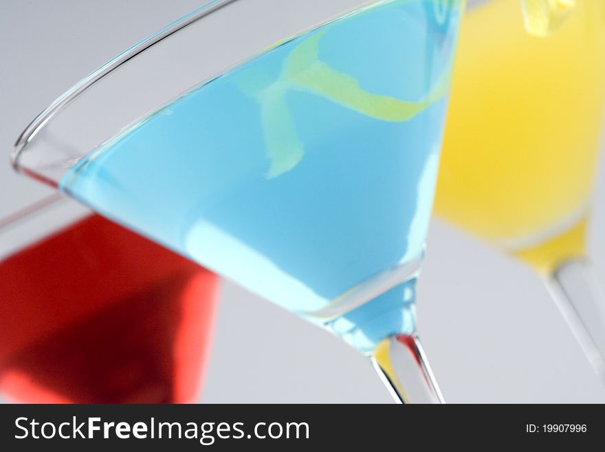 Colorful Tropical Martini style drinks with fruit & garnish closeup