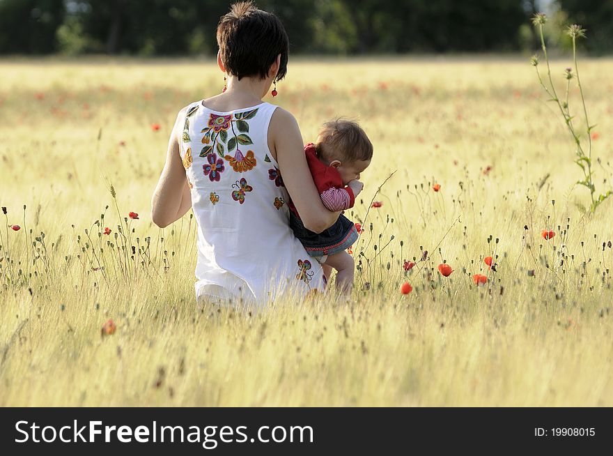 A mother with her daughter in a poppy field. A mother with her daughter in a poppy field