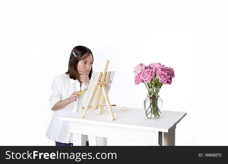 A young girl paints a picture of a vase of flowers. A young girl paints a picture of a vase of flowers.