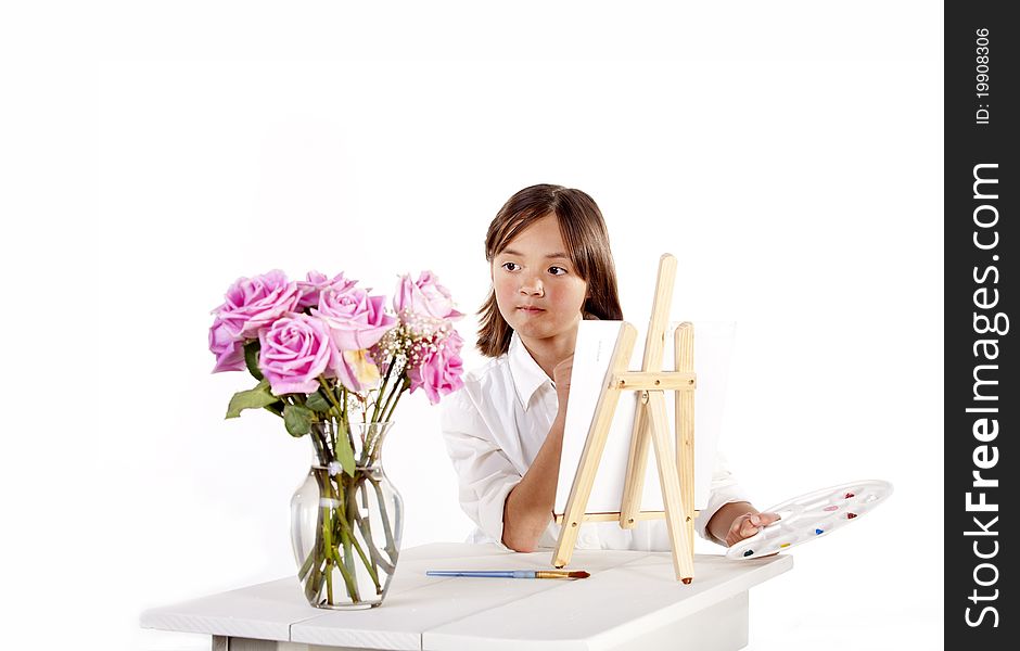 A young girl paints a picture of a vase of flowers. A young girl paints a picture of a vase of flowers.