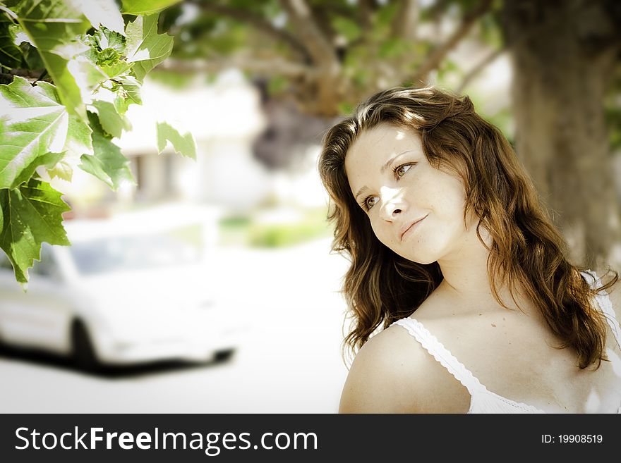 Young woman outdoors looking at a tree