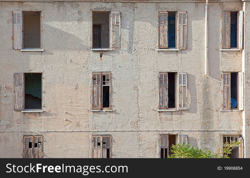 Facade of an old ruined house with broken windows