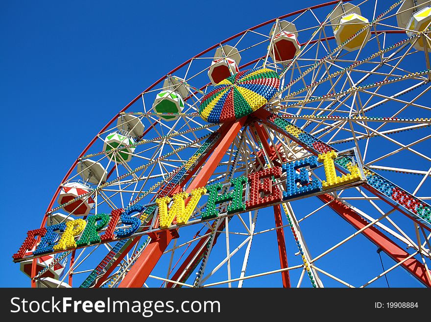 Colourful ferris wheel against blue sky