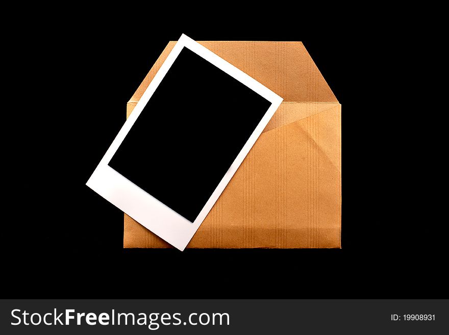 A vintage envelope with instant photo on black background. A vintage envelope with instant photo on black background