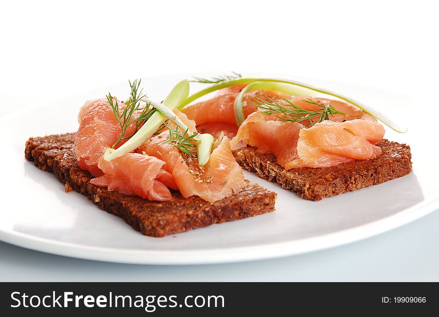 Fresh salmon sandwiches on a white plate