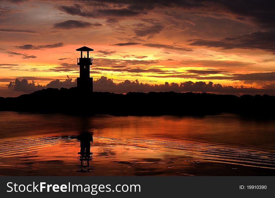 A Lighthouse In The Sunset Sky